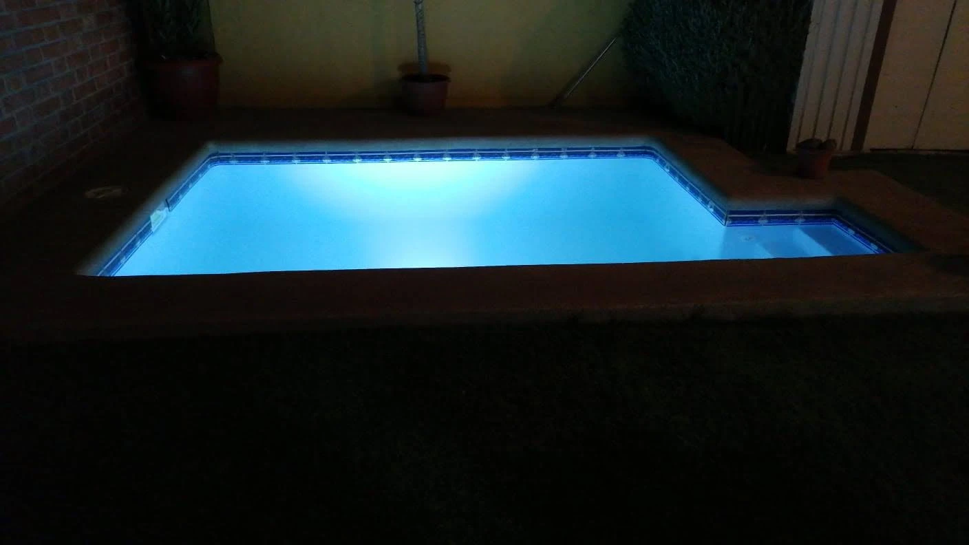 Borde Fulget color arcilla con la piscina iluminada de noche